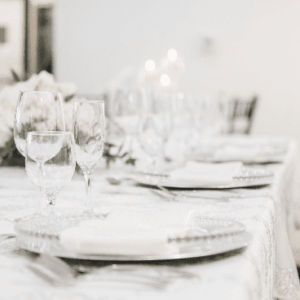 Elegant table setting with crystal glassware and fine china in a softly lit dining room.