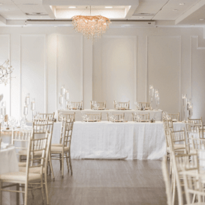 An elegant banquet hall set up with tables, chairs, and sophisticated decor.