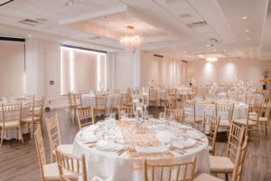 Elegant banquet hall set up for a formal event with arranged tables, chairs, and dinnerware.