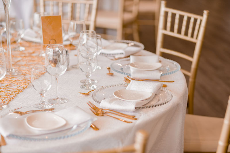 Elegant table setting for a formal event with gold accents and glassware.